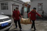 义工向胜利幸福院库房搬运蔬菜