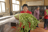 义工向胜利幸福院库房搬运蔬菜